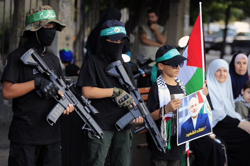 Masked boys hold machine gun toys during a protest in the southern port city of Sidon, Lebanon, Wednesday, July 31, 2024, to condemn the killing of Hamas political chief Ismail Haniyeh.