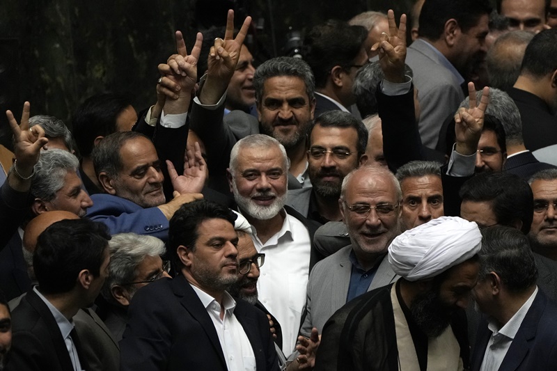 Palestinian Hamas chief Ismail Haniyeh, center, flashes a victory sign as he is surrounded by a group of Iranian lawmakers after the conclusion of the swearing-in ceremony of newly-elected Iranian President Masoud Pezeshkian at the parliament in Tehran, Iran, Tuesday, 30, 2024.