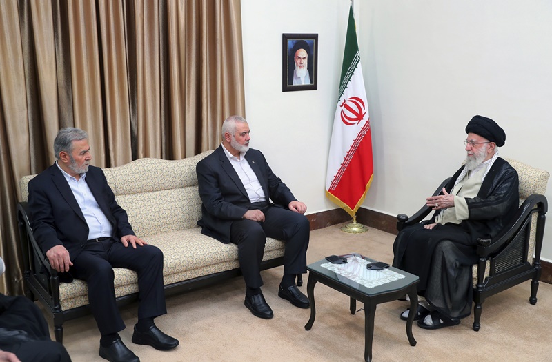 In this photo released by the office of the Iranian supreme leader, Supreme Leader Ayatollah Ali Khamenei, right, speaks with Hamas chief Ismail Haniyeh, center, and the leader of the Palestinian Islamic Jihad group Ziad Nakhaleh in their meeting in Tehran, Iran, Tuesday, July 30, 2024. A portrait of the late Iranian revolutionary founder Ayatollah Khomeini hangs on the wall.