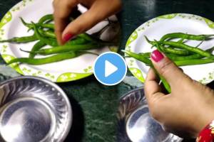 Kitchen jugad video woman is cutting green chillies by holding a wooden spoon in her thumb