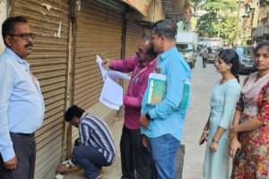 Municipal employees sealing a property in Kalyan East