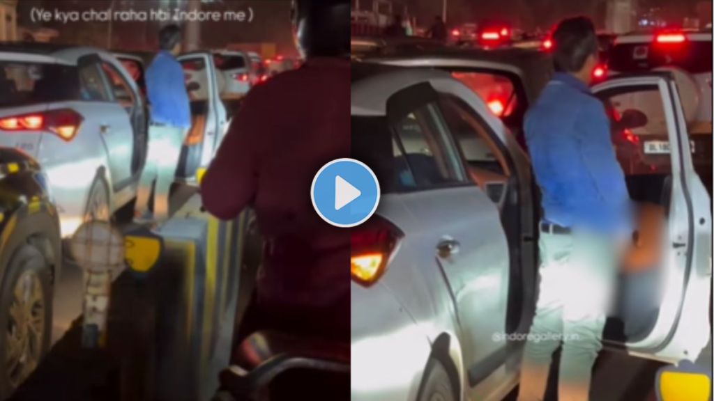 a man urinating near the gate of his car in heavy traffic on a road