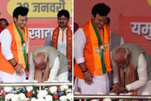 Modi touches Patparganj candidate feet