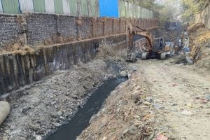 Road construction by laying slabs on drain in Wagle Estate