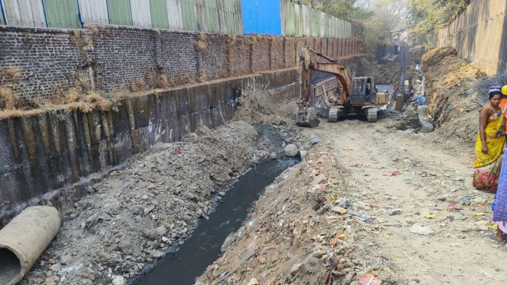 Road construction by laying slabs on drain in Wagle Estate